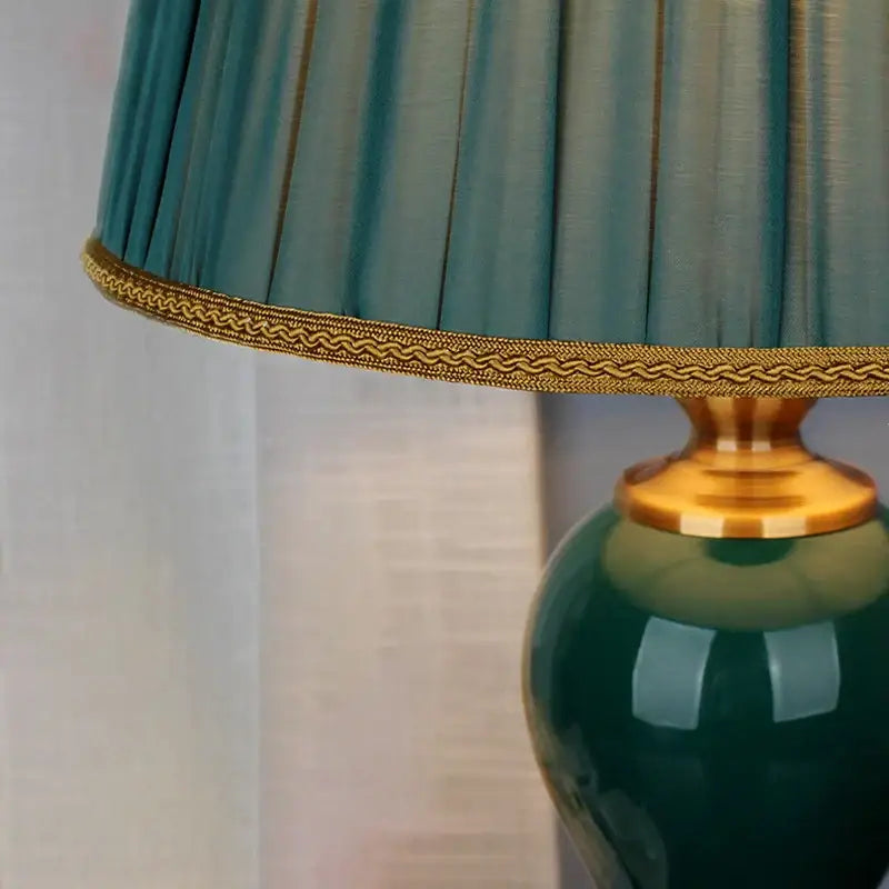 Modern teal green ceramic table lamp with pleated lampshade and gold trim for bedroom and living room use