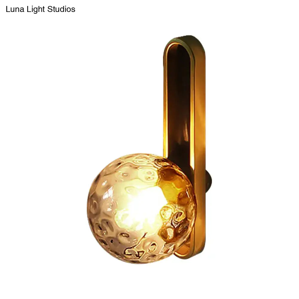 Modern teal and terracotta cylindrical side table with gold-toned orb wall light featuring a textured dimpled glass globe