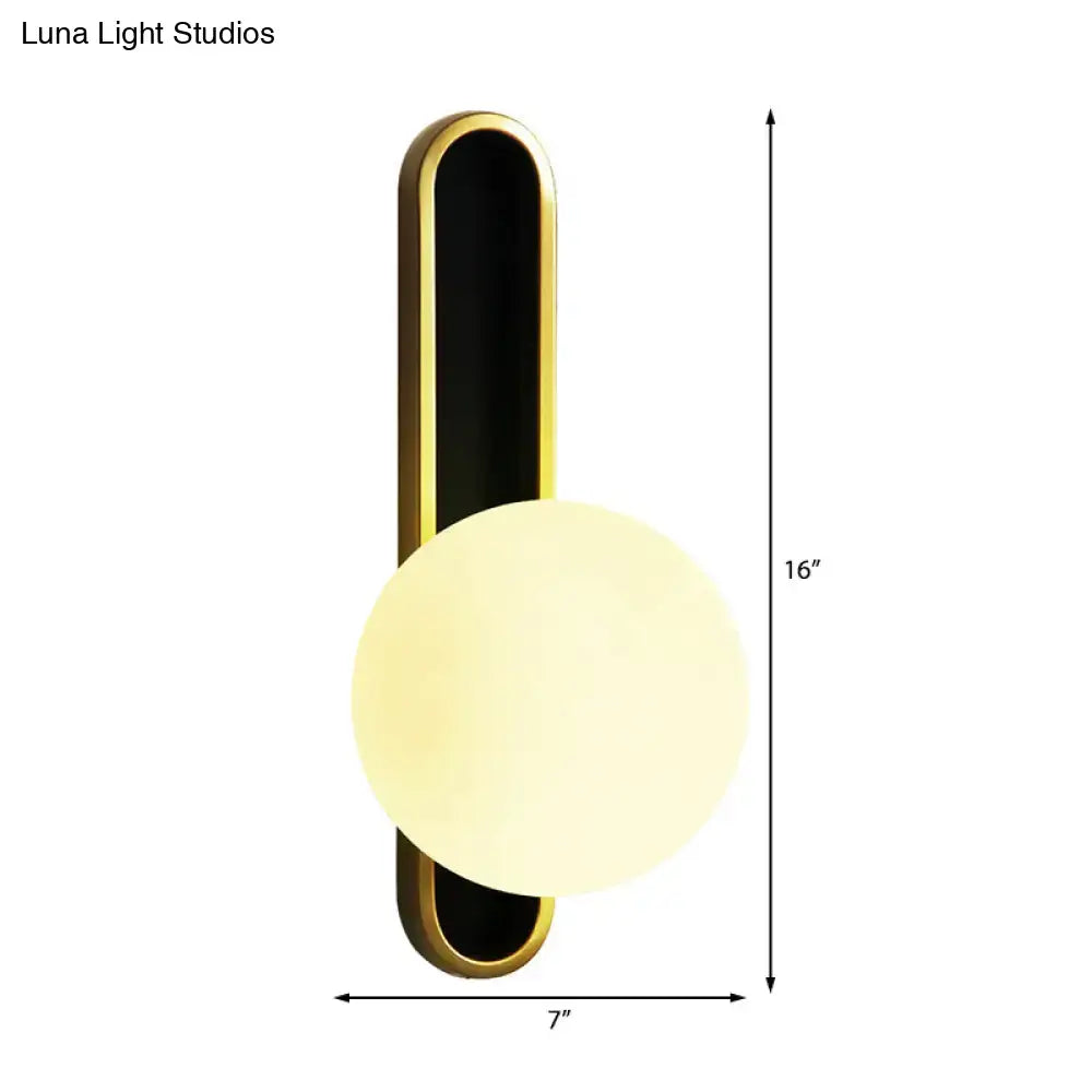 Modern teal and terracotta cylindrical side table paired with a gold and black orb wall light featuring a glowing diffuser