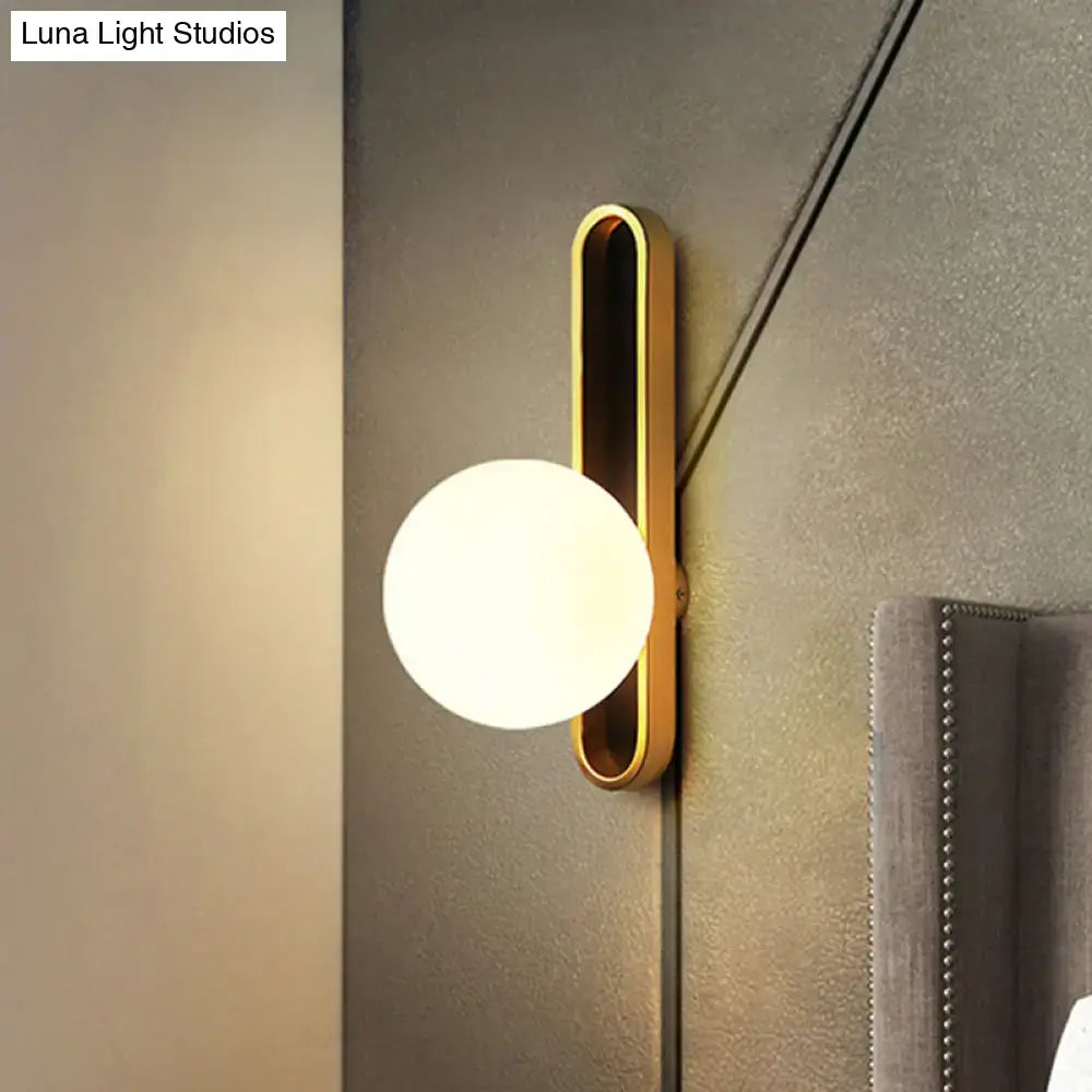 Modern teal and terracotta cylindrical side table paired with a gold orb wall light featuring a frosted glass globe