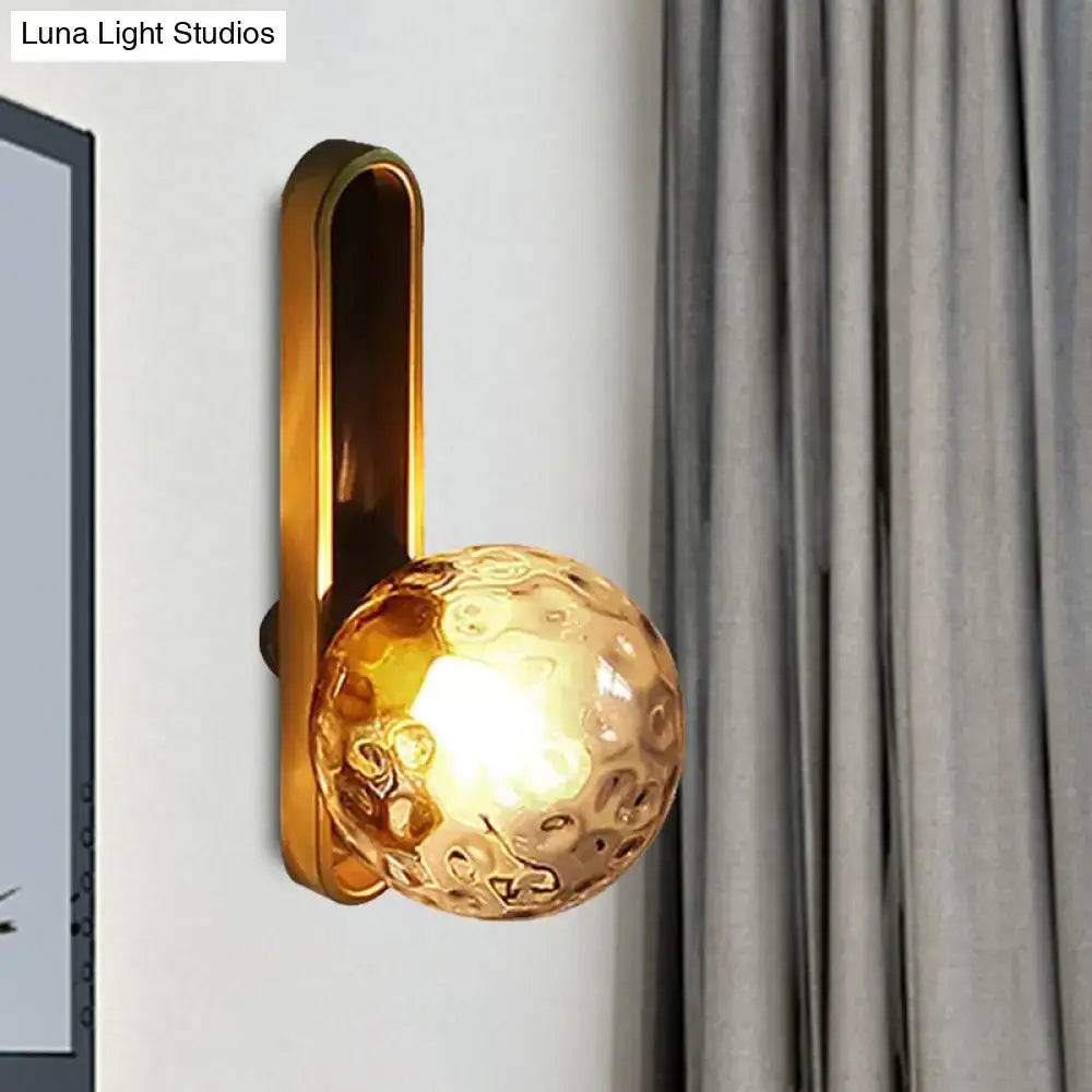 Modern teal and terracotta cylindrical side table with gold-toned orb wall light featuring textured amber glass globe