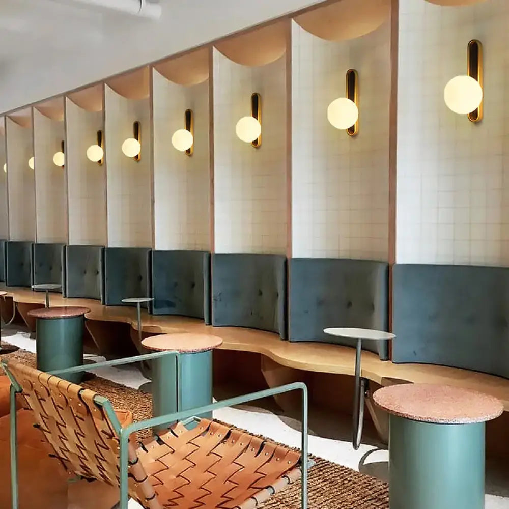 Modern teal and terracotta cylindrical side tables with textured tops for living room accent near orb wall light