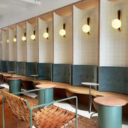 Modern teal and terracotta cylindrical side tables with textured tops for living room accent near orb wall light