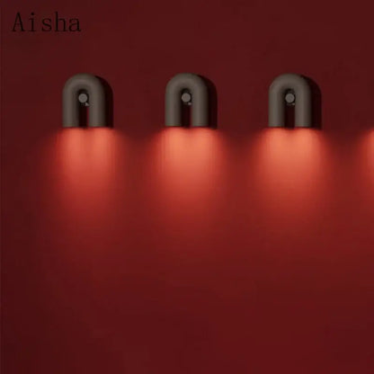 Three modern matte gray ceramic led u-shaped wall lamps emit warm red light for bedroom use