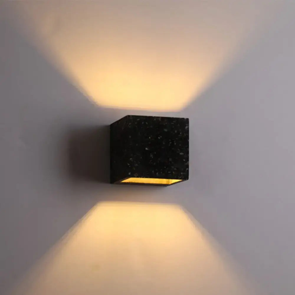 Modern terrazzo black speckled stone cube wall light with warm yellow e26 e27 light bulb casting angled beams