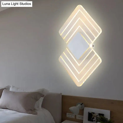 Modern textured silver and black direct wired led wall sconce with layered diamond-shaped warm white lighting