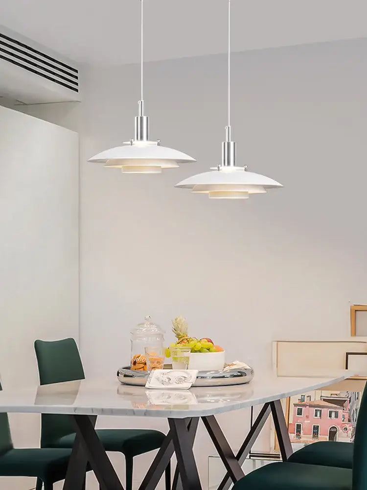 Two minimalist white hanging light pendant lamps with sleek silver metal fixtures by decorbites danish designer