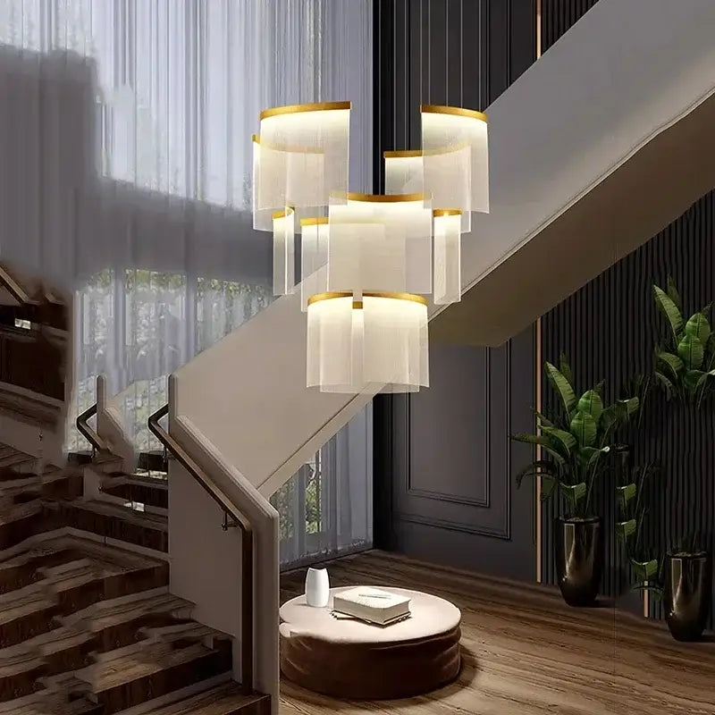 Modern tiered gold led ceiling chandelier with translucent white shades and gold accents above staircase seating