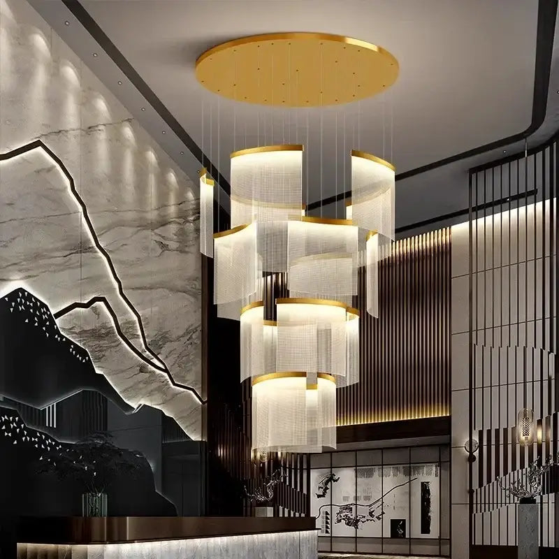 A modern tiered gold led ceiling chandelier with translucent white cylindrical shades for dining room lighting