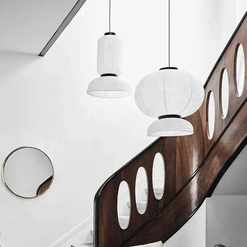 Modern tiered off-white paper pendant lights with black metal accents hang above wooden staircase decorbites designer led