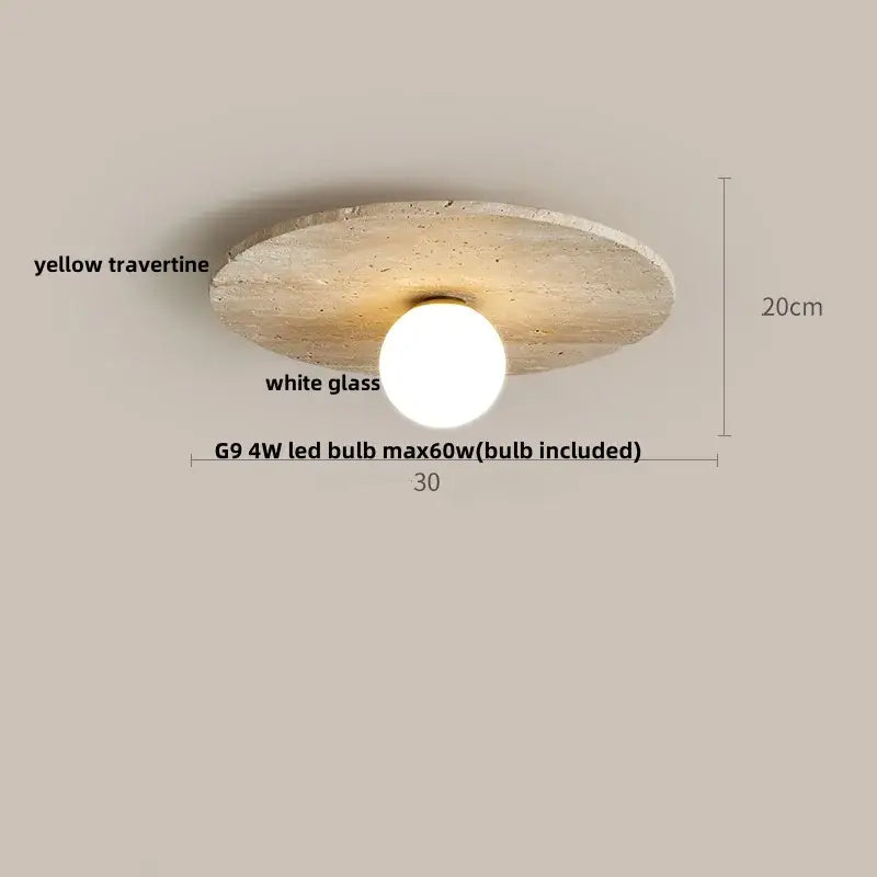 A modern ceiling light with a circular yellow travertine disc and a white decorbites glass ball led globe diffuser