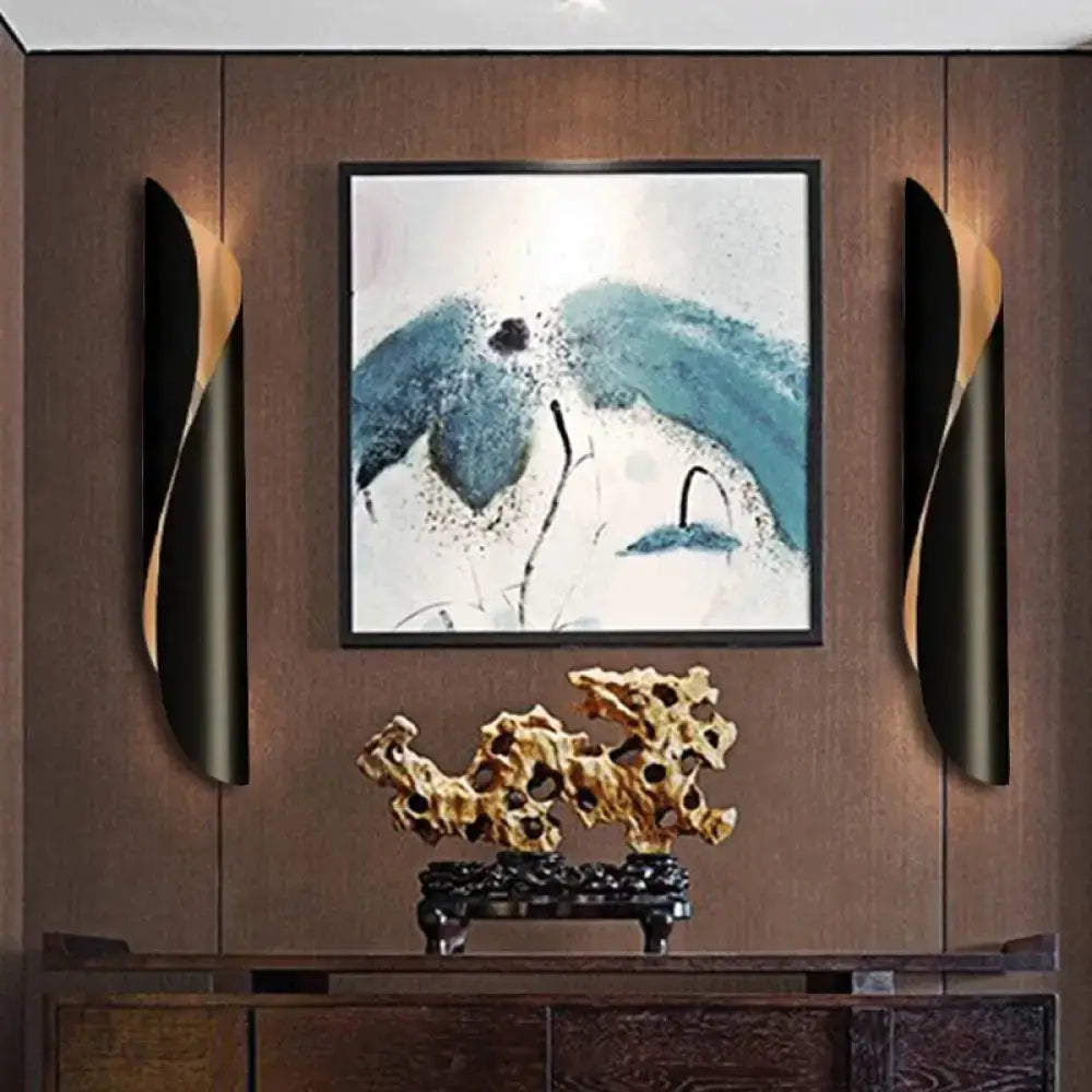 Golden intricately carved rock sculpture on dark wooden stand complementing modern twisted black and white wall lamp 110v-120v