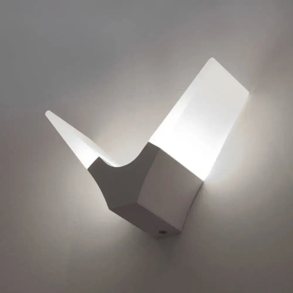 Modern white geometric v-shaped sconce light with angular minimalist design emitting warm white for bedroom use