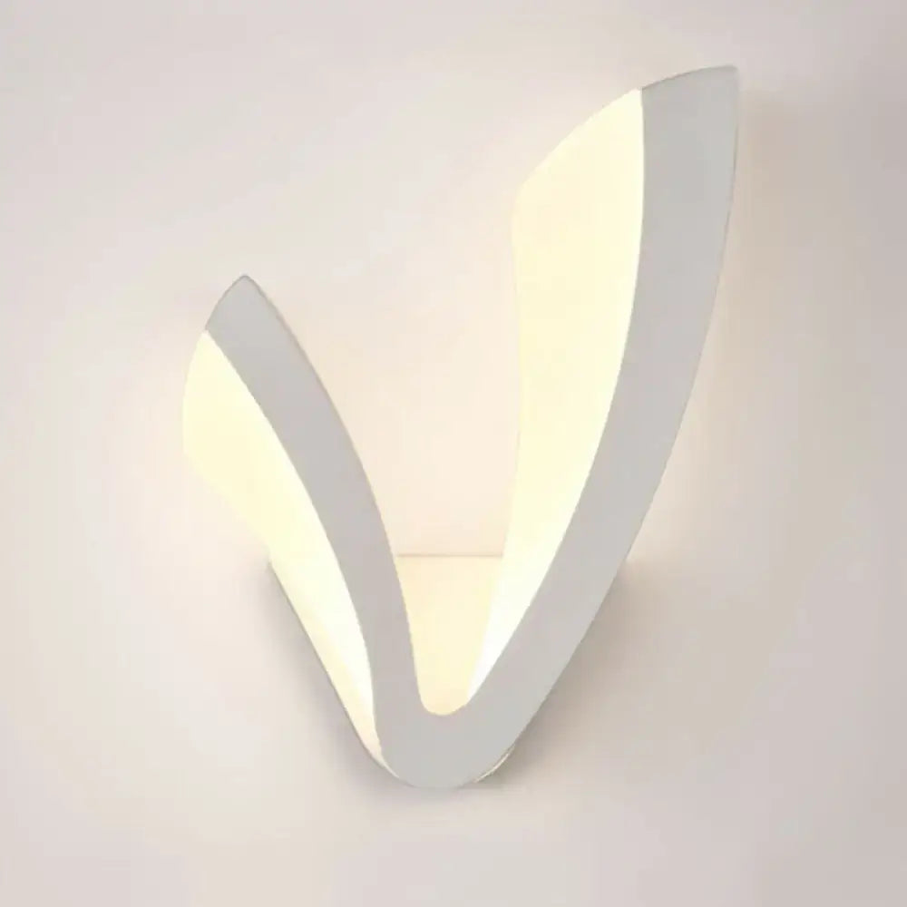 Modern v shaped white wall mounted light with sleek minimalist design providing warm white ambient bedroom lighting
