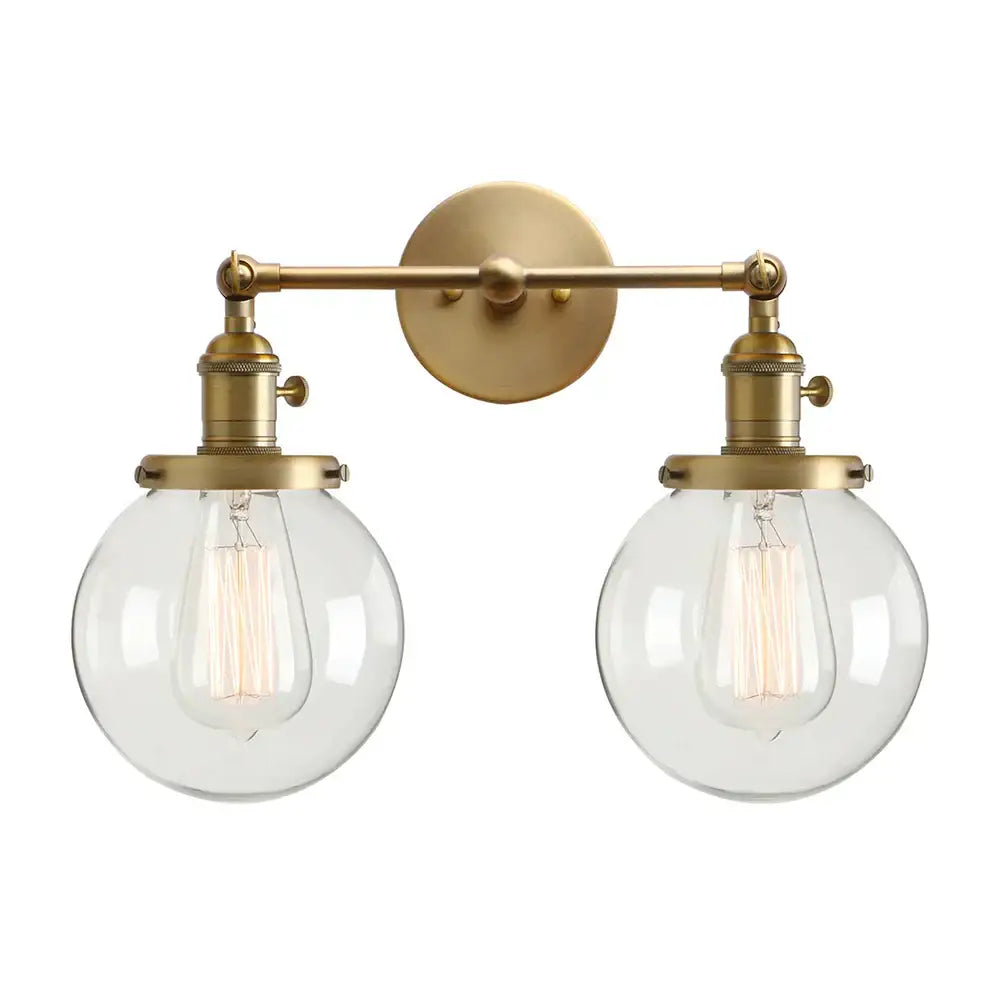 Modern vintage brass wall sconce with double ball heads clear glass globe shades and vintage edison bulbs for bedroom lighting