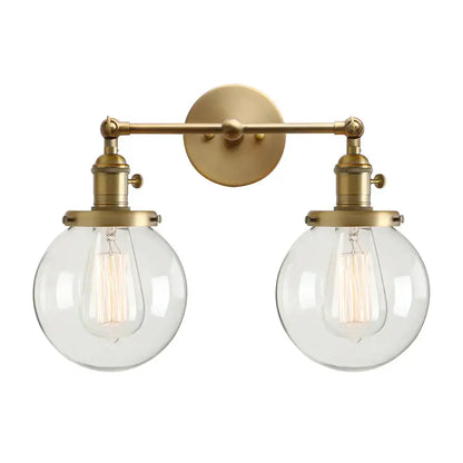Modern vintage brass wall sconce with double ball heads clear glass globe shades and vintage edison bulbs for bedroom lighting