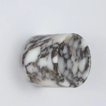 A translucent cylindrical led wall lamp with a swirling white and dark gray resin marble pattern for bedroom use