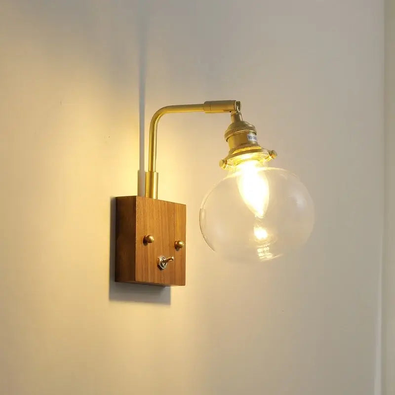 Modern walnut copper wall sconce with brass finish wooden base and clear glass globe bulb for stair lighting