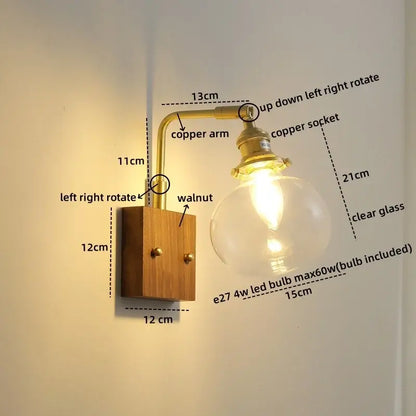 Modern walnut copper wall sconce with brass arm and clear glass globe bulb mounted on walnut wood base for stair lighting