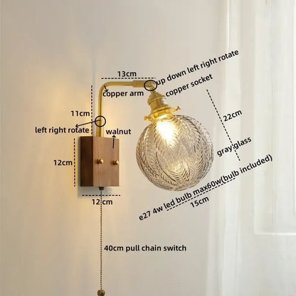 Modern walnut and copper wall sconce with clear gray glass globe and walnut base for stair light illumination
