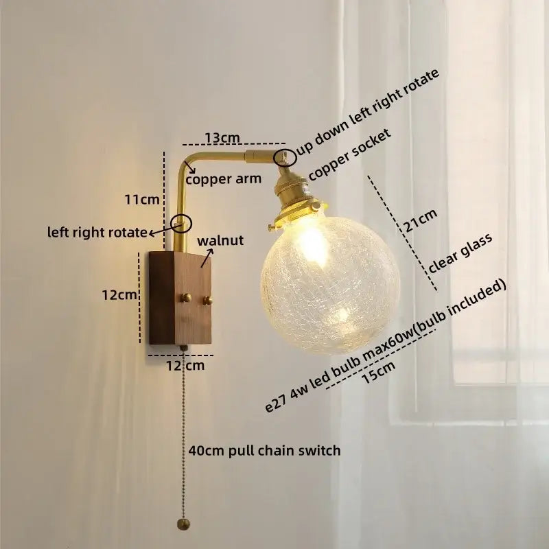 Modern walnut copper wall sconce with clear glass globe bulb and articulated copper arm on a walnut base
