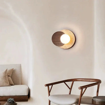 Modern walnut and cork led wall lamp with circular design featuring dark wood and textured beige stone around warm bulb