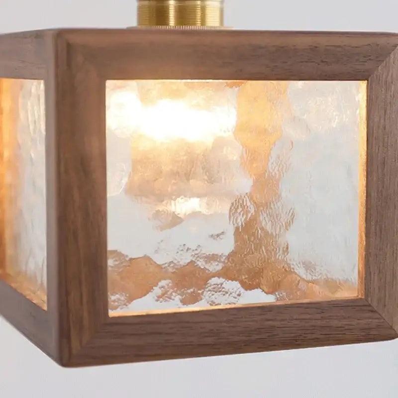 Modern walnut wood pendant light with clear textured frosted glass panels and brass finish for dining room