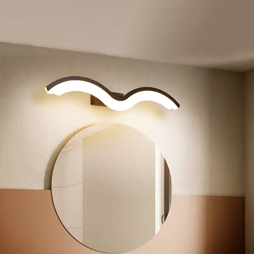 Modern wavelet black and white wall sconce with a sleek black frame and soft white LED illuminated curve for bathroom use