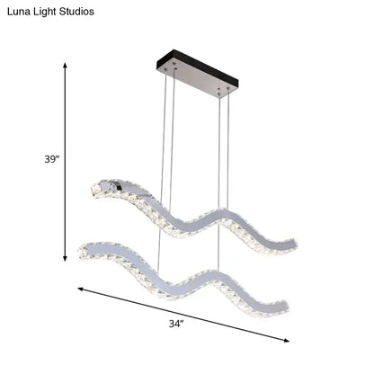 Modern wave-shaped stainless steel hanging light fixture with clear crystal accents and sleek chrome finish for office use