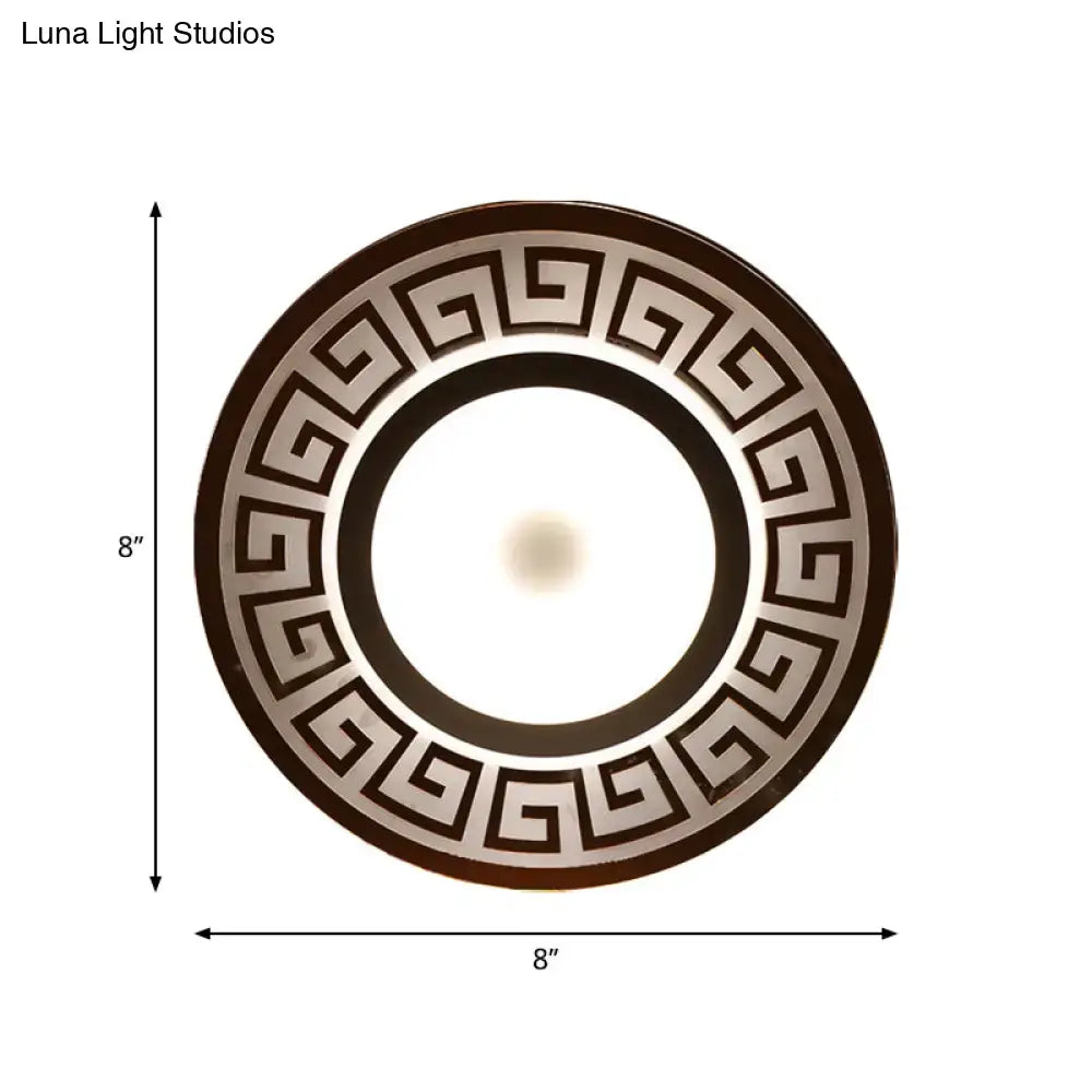 Modern white acrylic wall lamp with circular dark brown and metallic silver greek key border for bedroom use