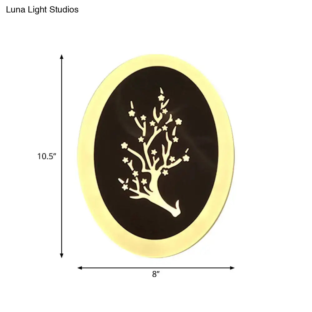 Gold-framed oval wall art with a delicate white tree on dark background paired with modern white acrylic cloud led wall lamp