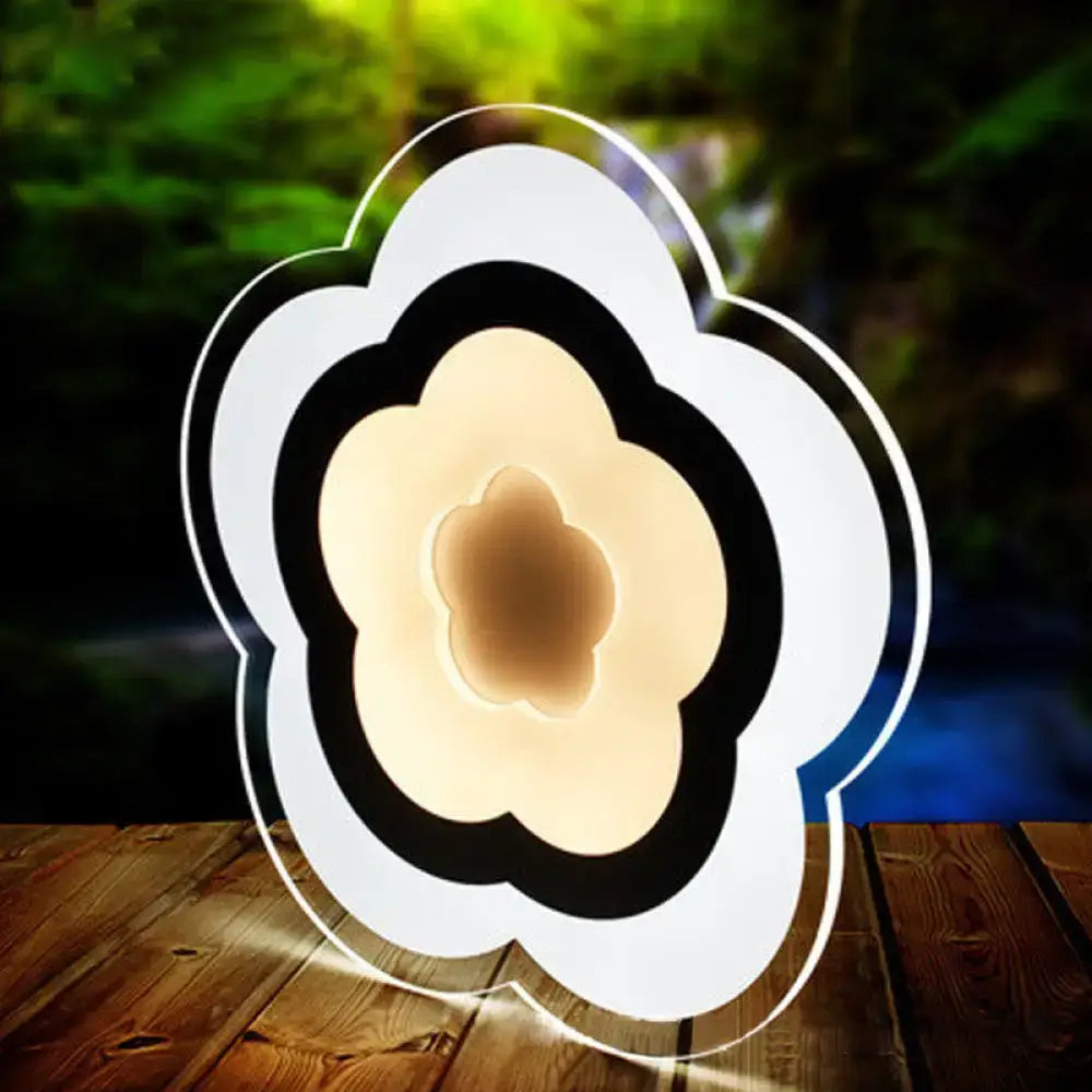 Modern white acrylic cloud led table lamp with sleek black accents emitting warm ambient light for bedroom use