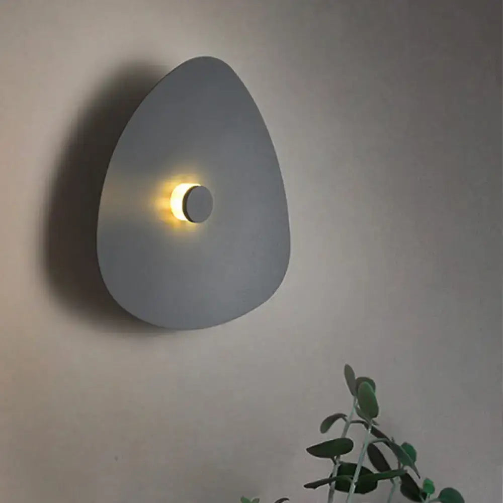 Modern gray teardrop-shaped flaky sconce light with warm circular light in white acrylic bedroom wall fixture