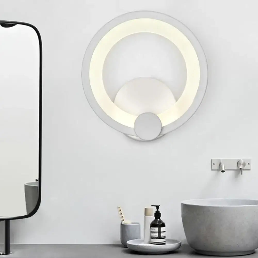 Modern white acrylic sconce light with layered concentric rings emitting soft warm light for bedroom walls