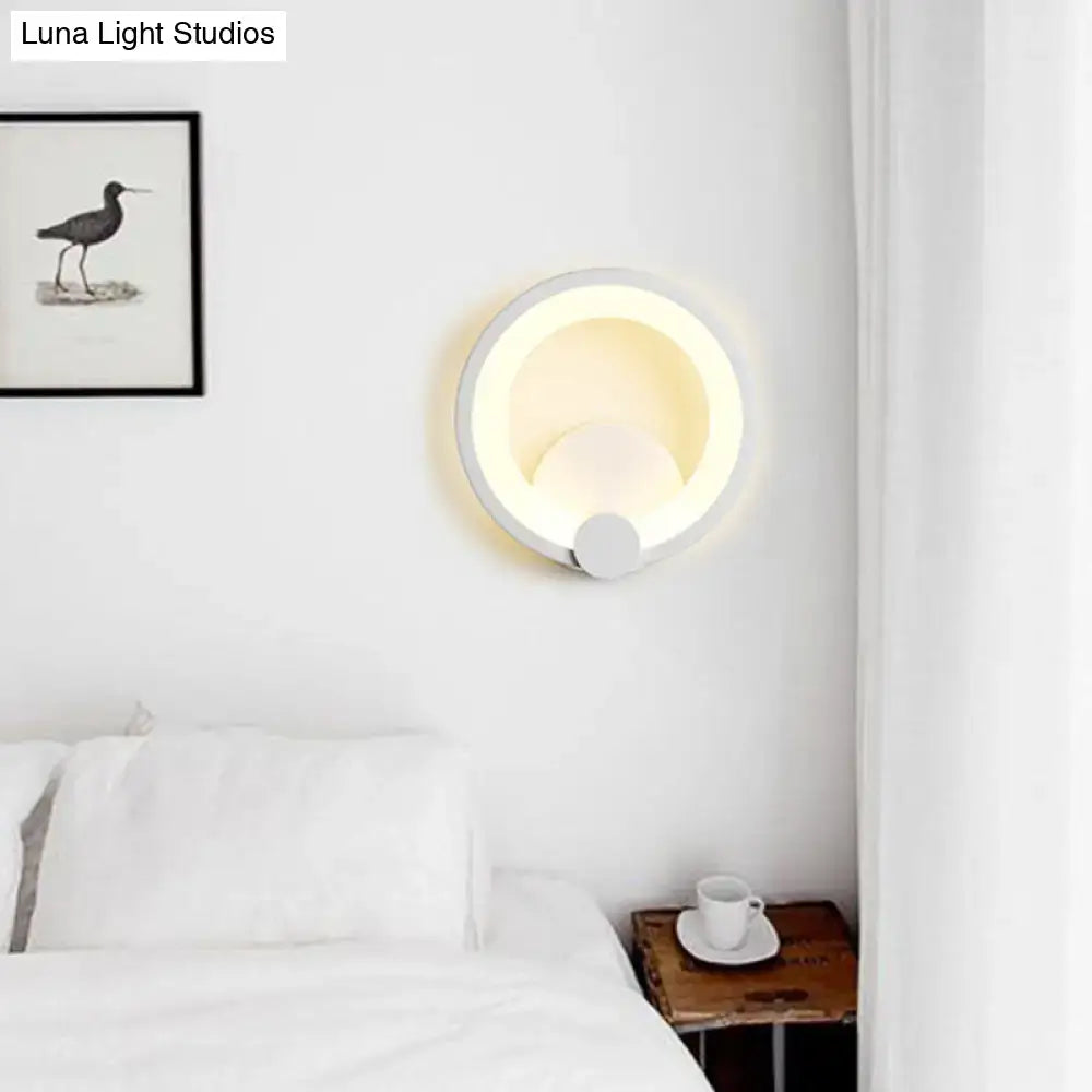 Modern white acrylic sconce light with circular design and warm ambient lighting for bedroom wall installation
