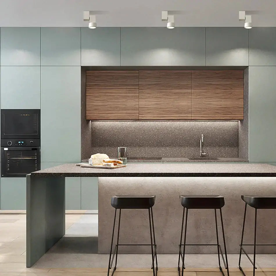 Modern kitchen island with matte gray concrete countertop illuminated by adjustable angle downlight offers under-cabinet lighting