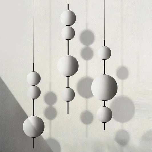 Modern white and black glass globe pendant light with spherical light sources and black rods for dining room use