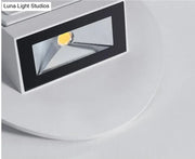 Modern white and black wall sconce bedroom led spotlight with rectangular design and visible yellowish light source