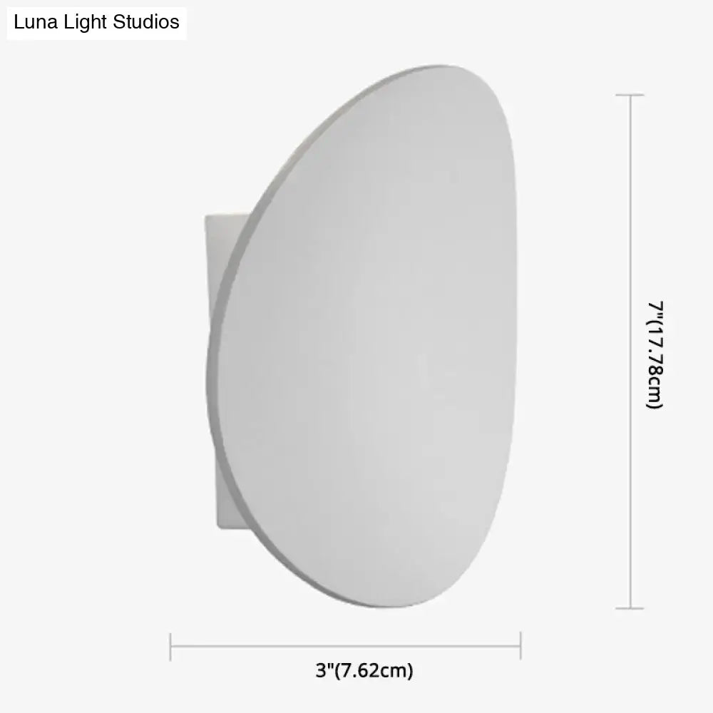 Modern style white and black wall sconce with a sleek oval face and rectangular base for bedroom led spotlight lighting