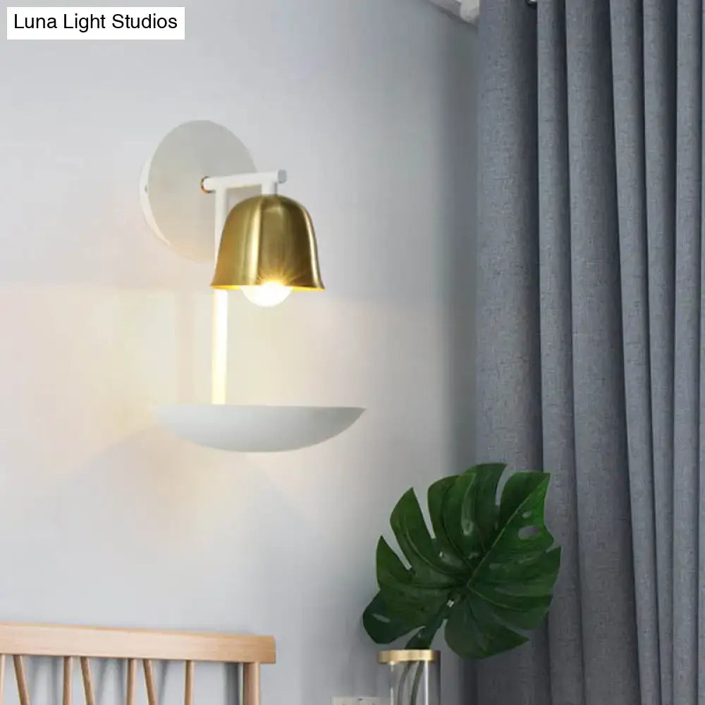 Modern white and brass bell metal sconce with gold bell-shaped shade and white circular base for bedroom wall lighting