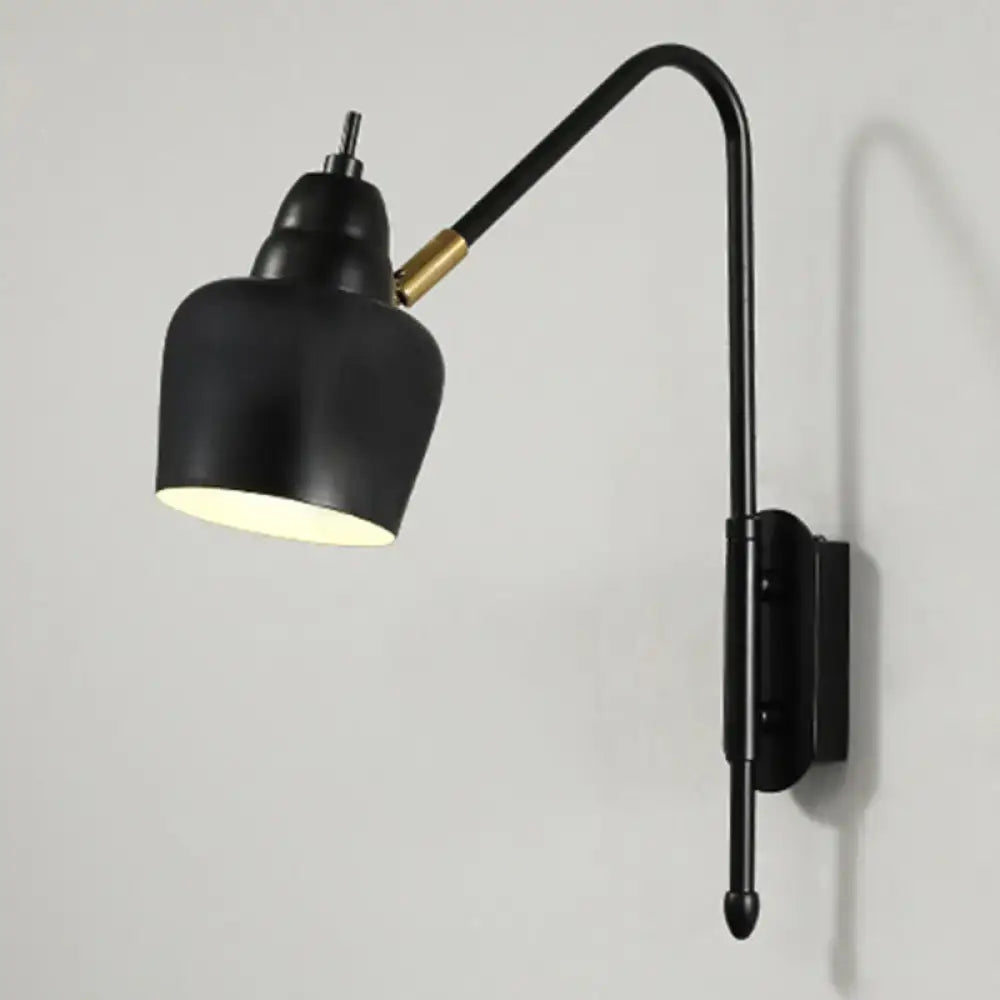 Black wall-mounted modern light type with curved arm and brass accent for bedroom reading use