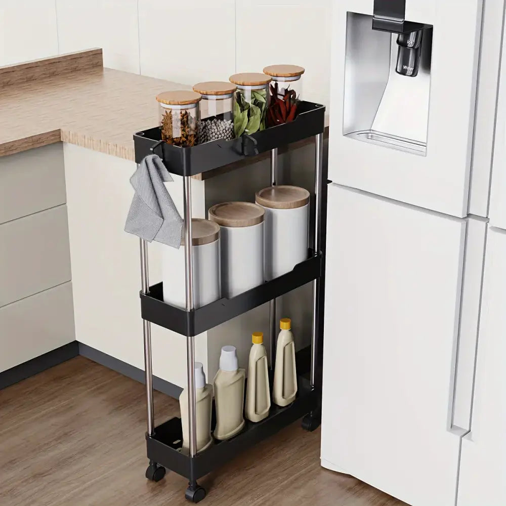 Black three-tier rolling kitchen cart with stainless steel legs and wheels holding white canisters for bathroom storage rack