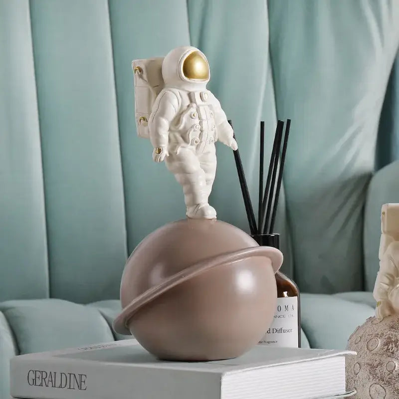 Modern white and gold astronaut phone holder figurine standing on a matte taupe planet globe for living room decorbites astronaut phone decor