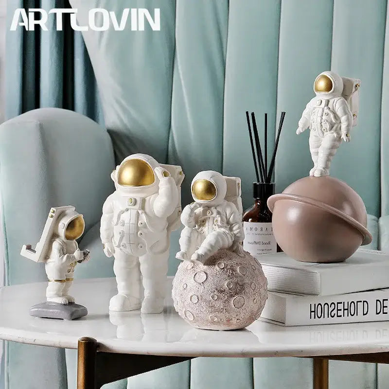 Modern white and gold astronaut phone holder figurines with detailed suits displayed on a marble table for decorbites astronaut phone use