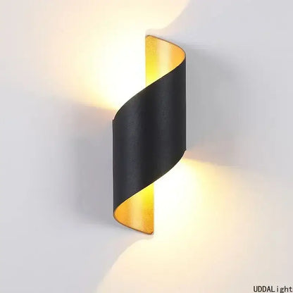 A sleek black and gold spiral outdoor wall lamp with a modern twisted design for patio lighting