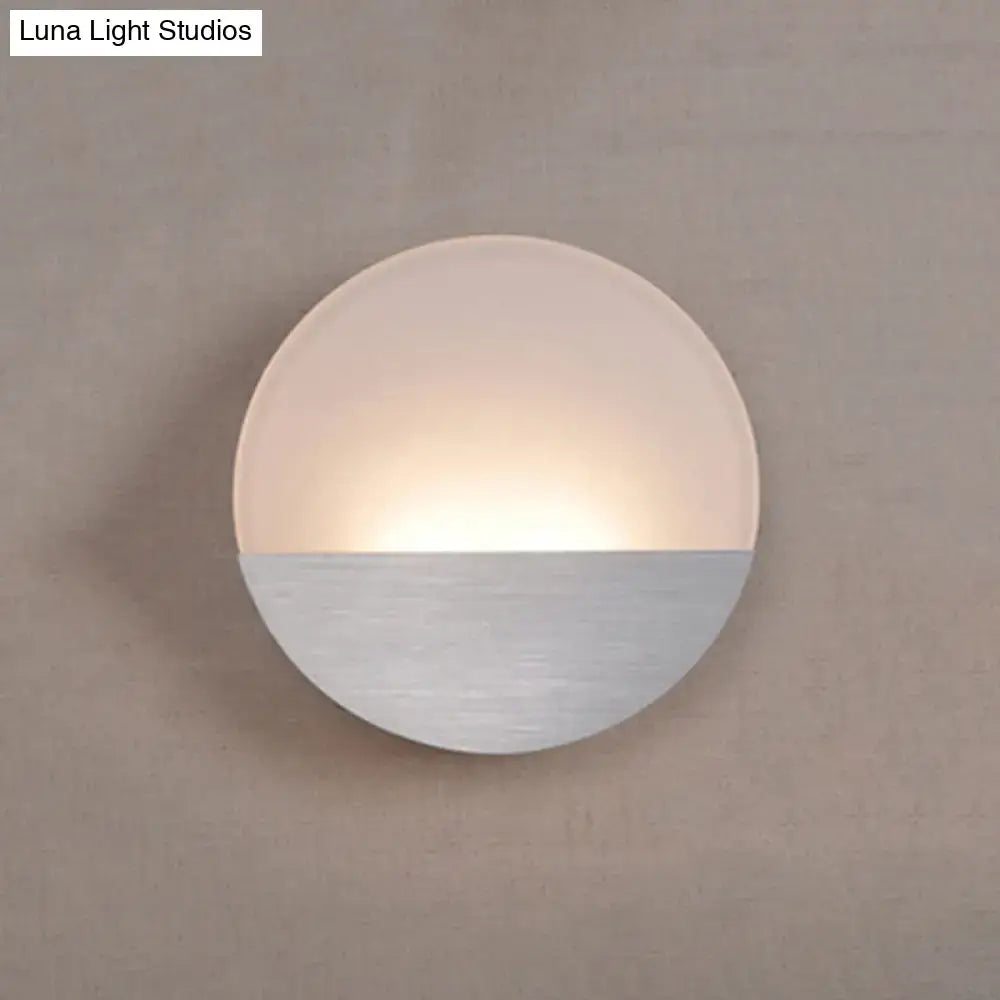 Modern white and silver led sconce light with frosted glass and brushed metal emitting warm glow for bedroom use