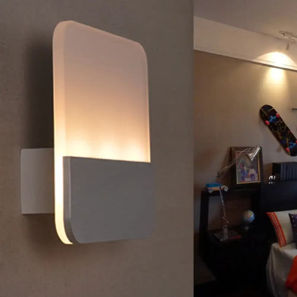 Modern white and silver led sconce light with rectangular shape and warm diffused glow for bedroom use