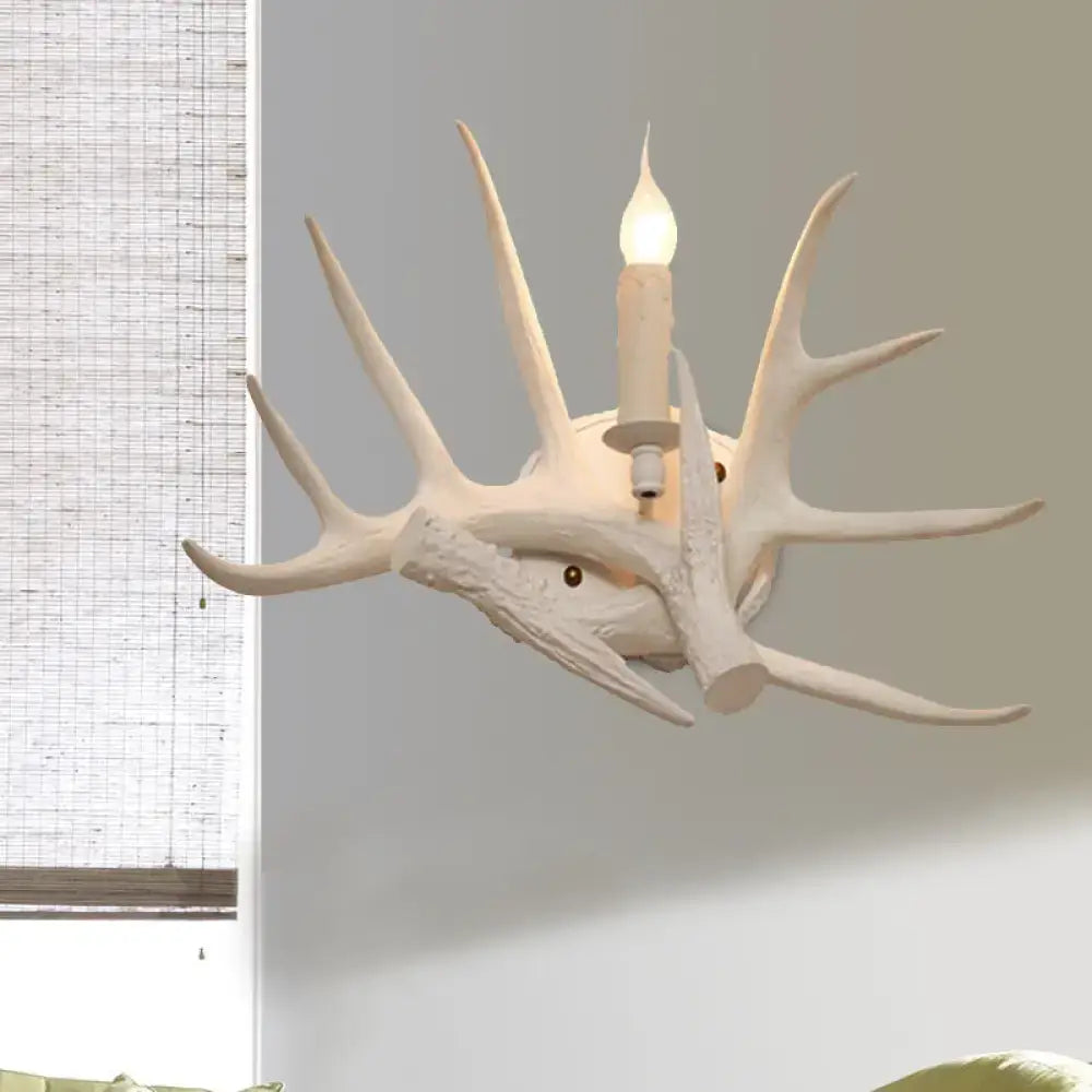 Modern white antler resin shade wall sconce featuring a single lit candle-style bulb for living room light