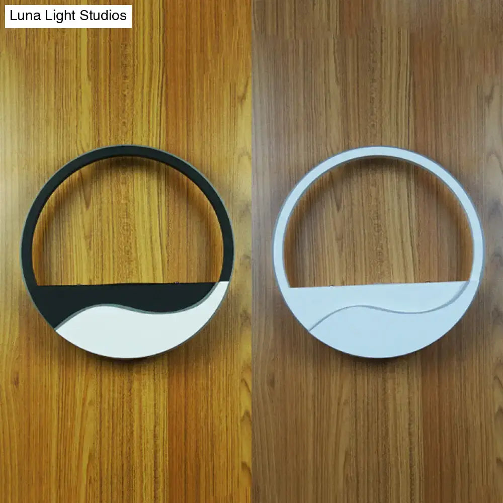 Modern white and black acrylic wall sconce with sleek curved edges providing warm white light for bedroom use