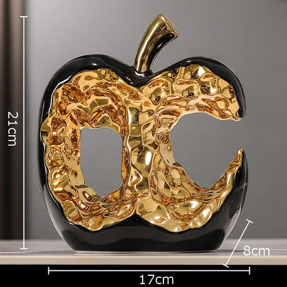 Glossy black and gold ceramic apple sculpture with textured metallic interior for modern desk decoration